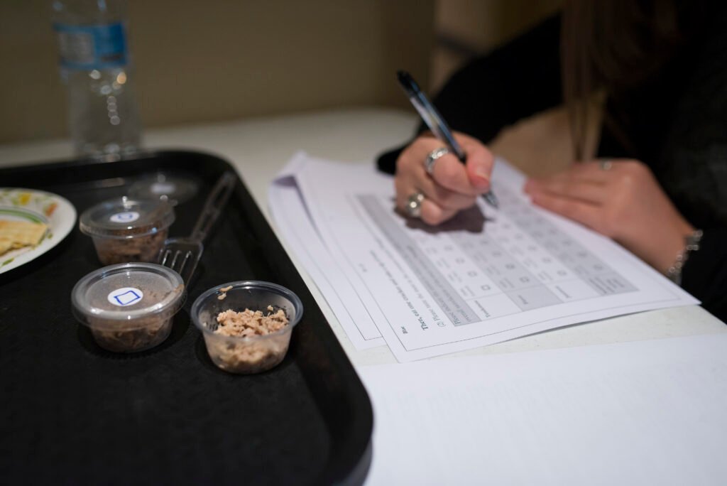 Meat preference survey of Beef, Pork and Goat conducted by Ag Econ Students. Student tasting a sample of food and completing a questionnaire, all part of Researching Consumer Food Preferences